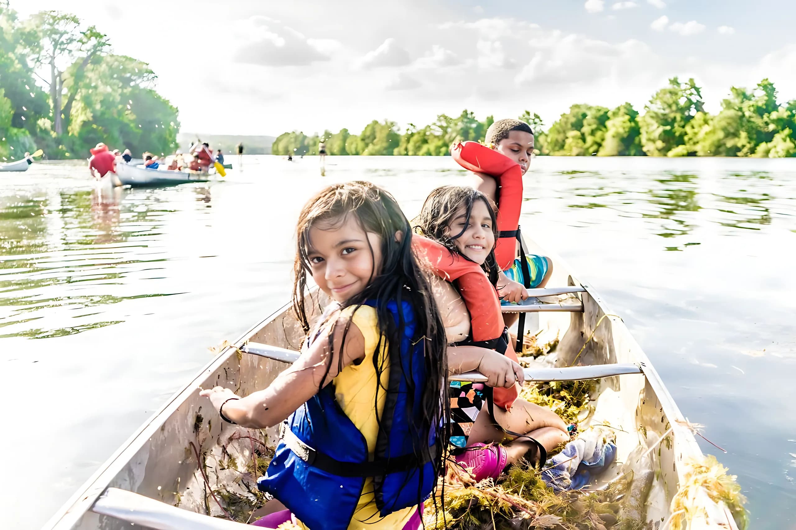 Children smiling while canoeing on Lady Bird Lake in Austin