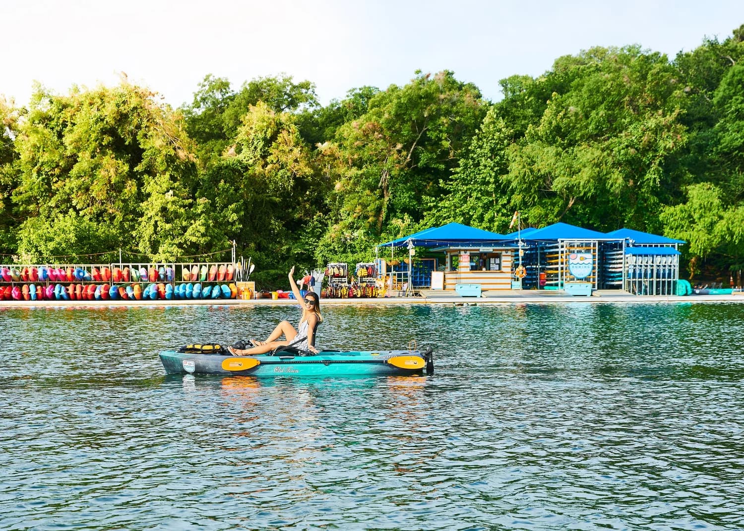 Rowing Dock seen from the water, lined with colorful kayaks and paddleboards