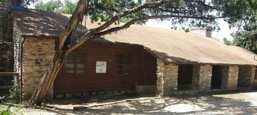 The historic timber-and-stone Girl Scout cabin tucked among the trees at Zilker