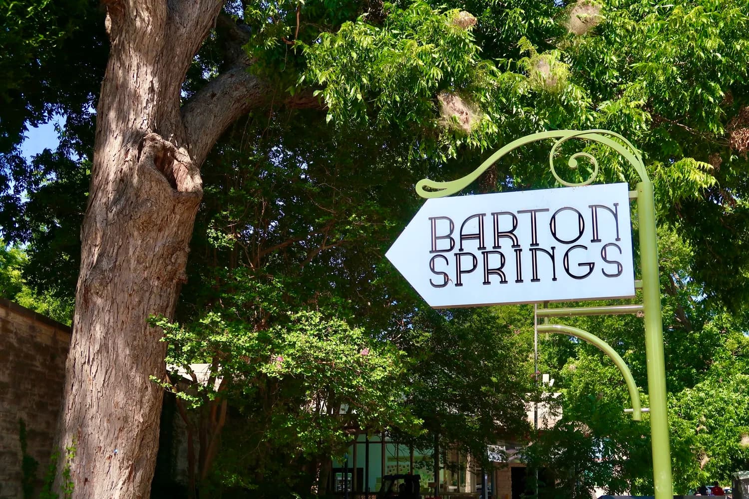 A vintage-style wrought-iron sign pointing the way to Barton Springs