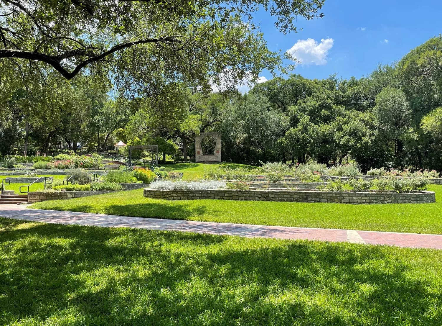 Garden beds and pathways at the Zilker Botanical Garden under live oaks