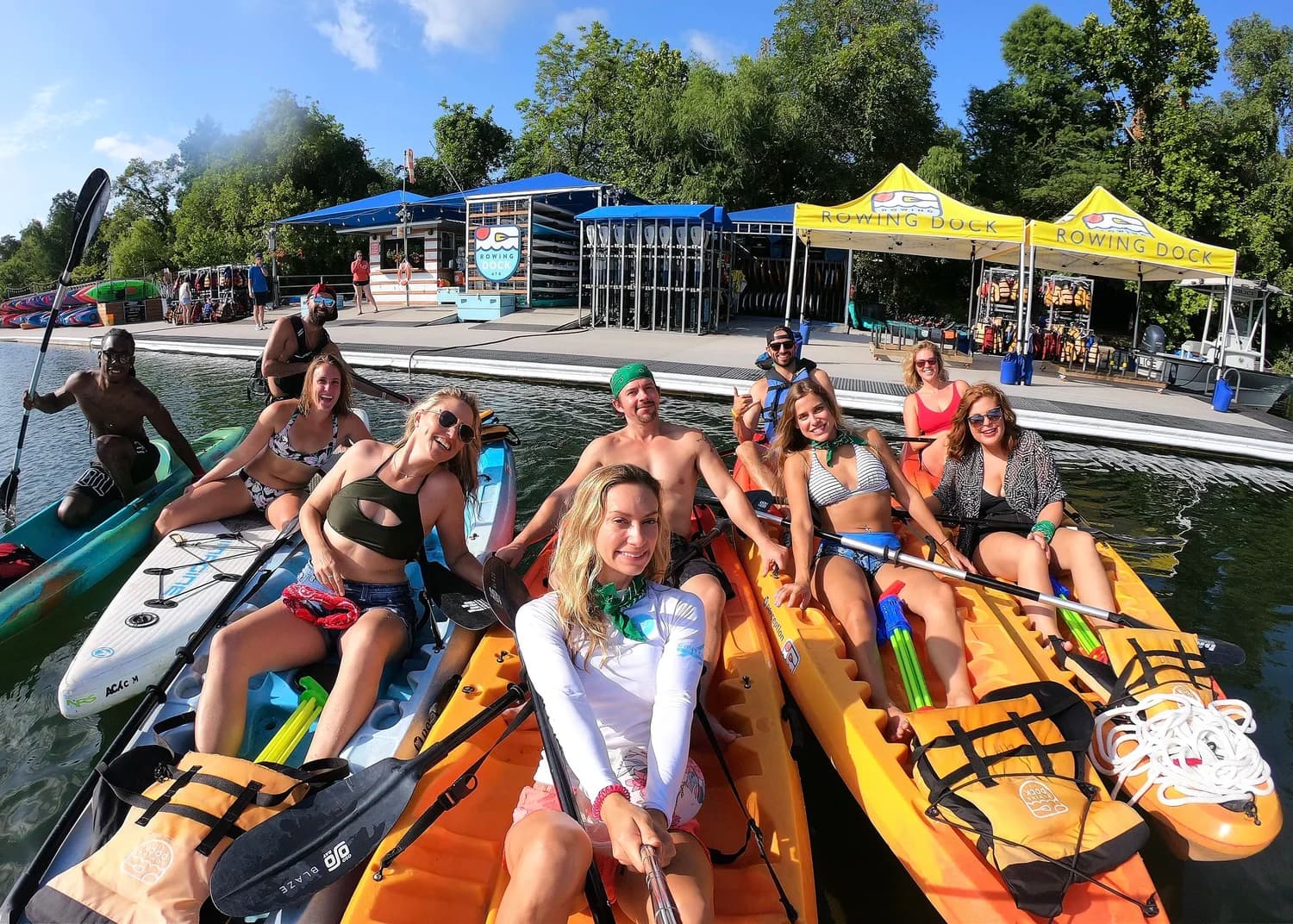 A group of paddlers on kayaks and paddleboards at the dock on Lady Bird Lake